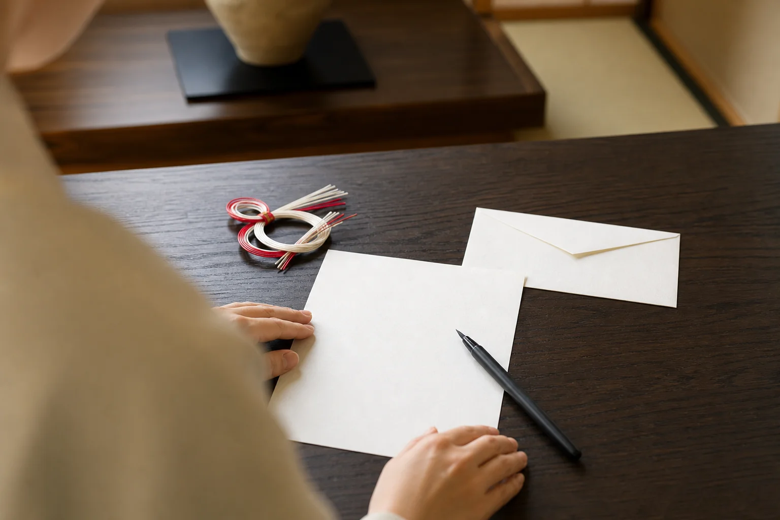 結納のあとにお礼状を書く場面の写真。便箋と封筒、紅白の水引の飾り